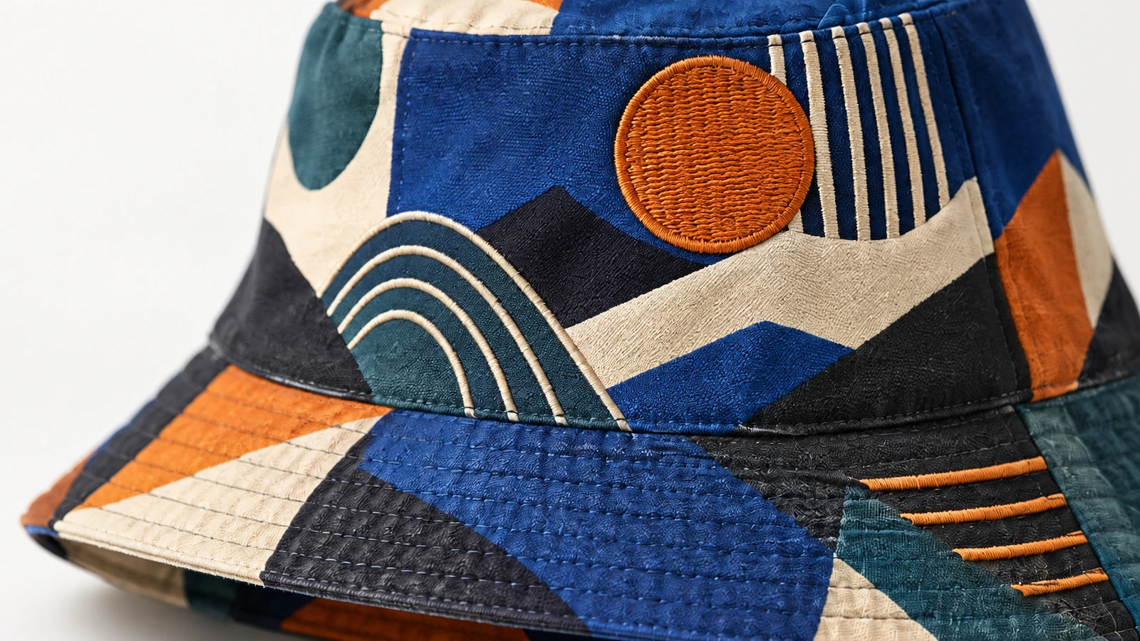 Close-up kain bucket hat bermotif, pinggiran yang dijahit, dan bordir melingkar oranye