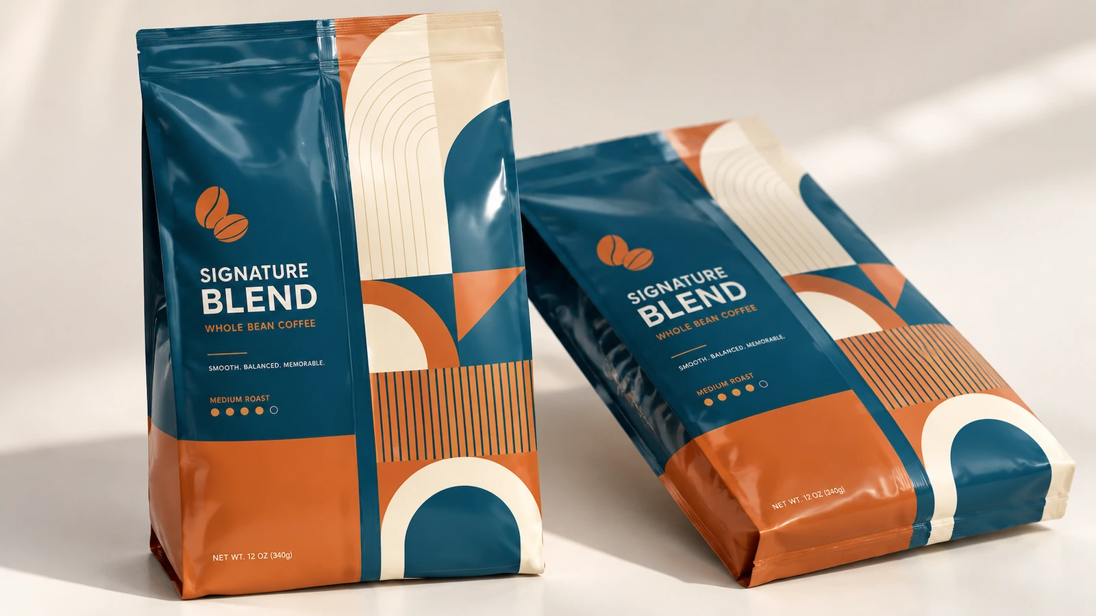 Satu kantong kopi berdiri dan satu kantong rebah, dengan artwork teal dan oranye