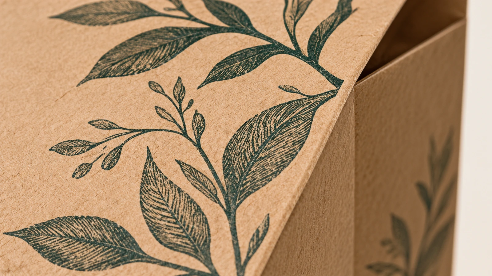 Close-up cetakan daun hijau pada sudut kantong kertas cokelat